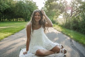 A sitting down picture of a senior girl.