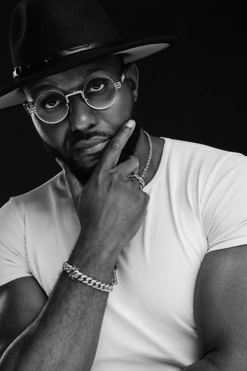 Orlando portrait photographer Ray Alvarez — artistic black and white male portrait with hat and glasses in moody studio lighting