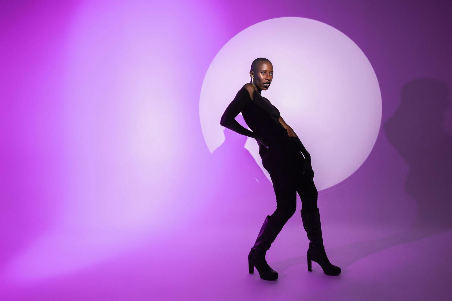 Orlando creative portrait photographer Ray Alvarez — moody studio portrait with large circular purple backlight and dramatic silhouette