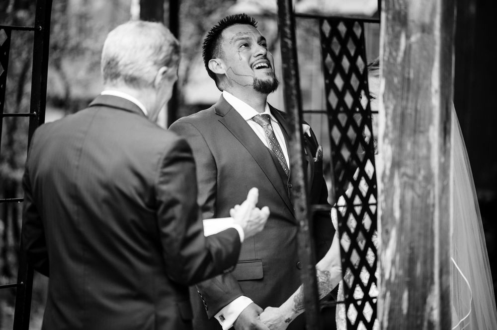 Emotional black and white candid moment during outdoor wedding ceremony.