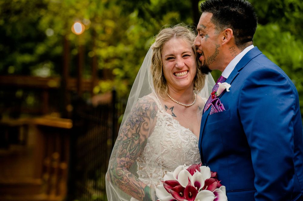Intimate outdoor wedding moment captured with natural lighting and burgundy bouquet.