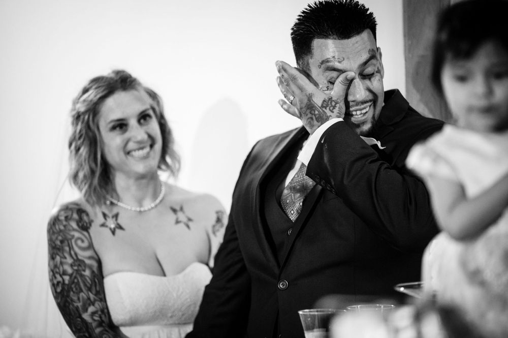 Candid black and white moment of joyful emotional reactions during wedding speeches.
