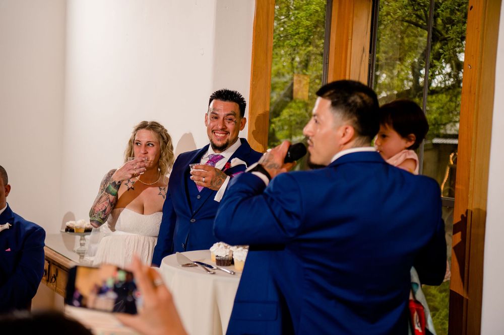 Wedding reception candid moment with guests in blue attire during indoor celebration.