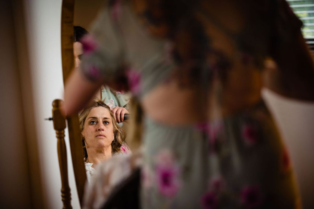 Artistic reflection shot of a bride getting ready in a mirror.