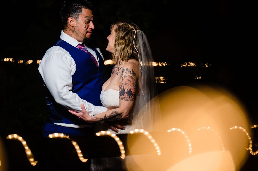 Couple sharing intimate moment with string lights creating bokeh effect.