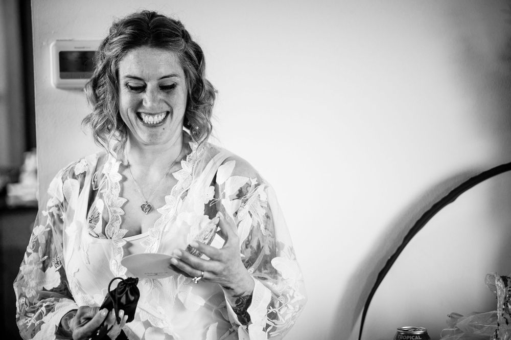 Candid black and white portrait of person in floral robe during wedding preparations.