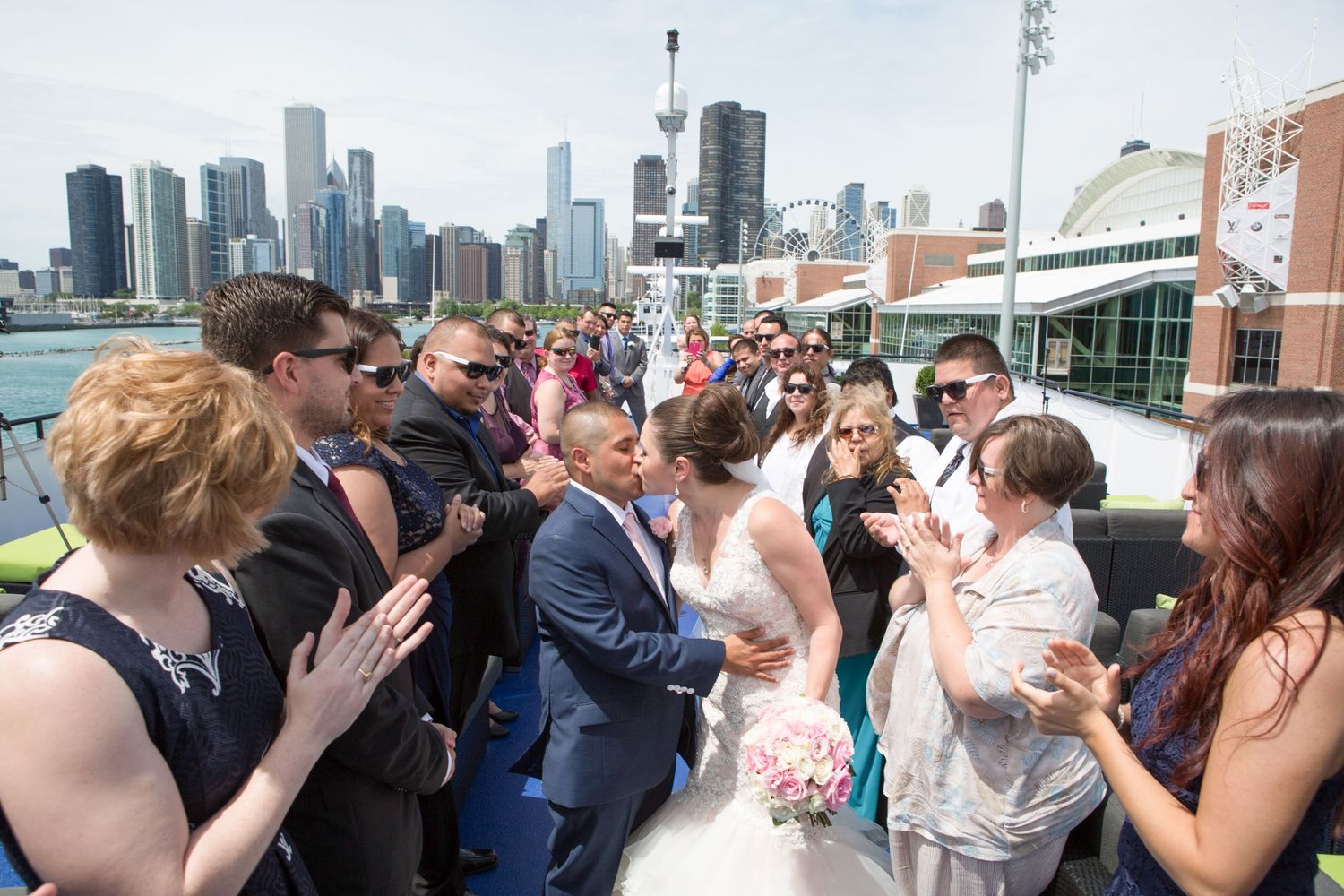 Wedding party celebrates on a rooftop with Chicago skyline in the background.