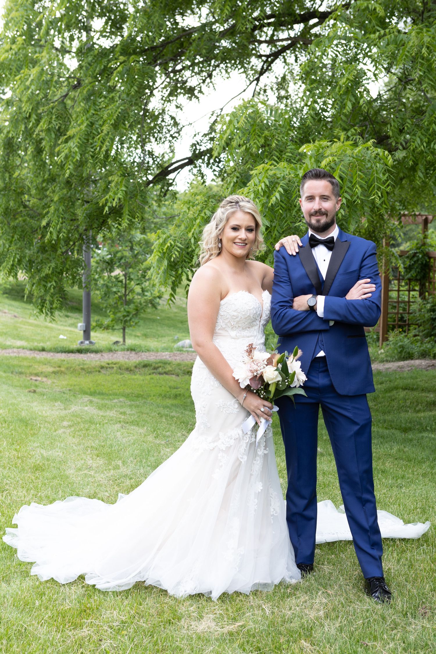 Wedding portrait under weeping willow tree with beautiful landscaped garden background.