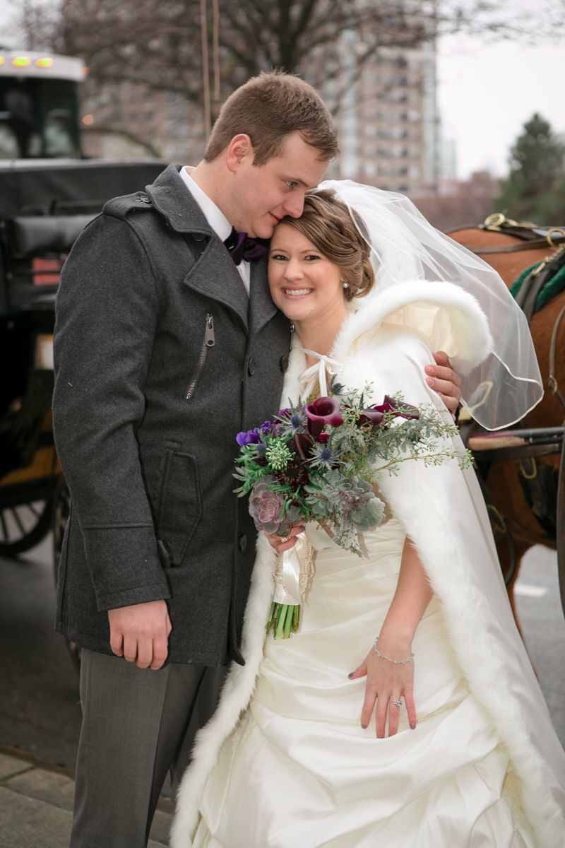 Newlyweds share intimate moment outdoors with winter bouquet.