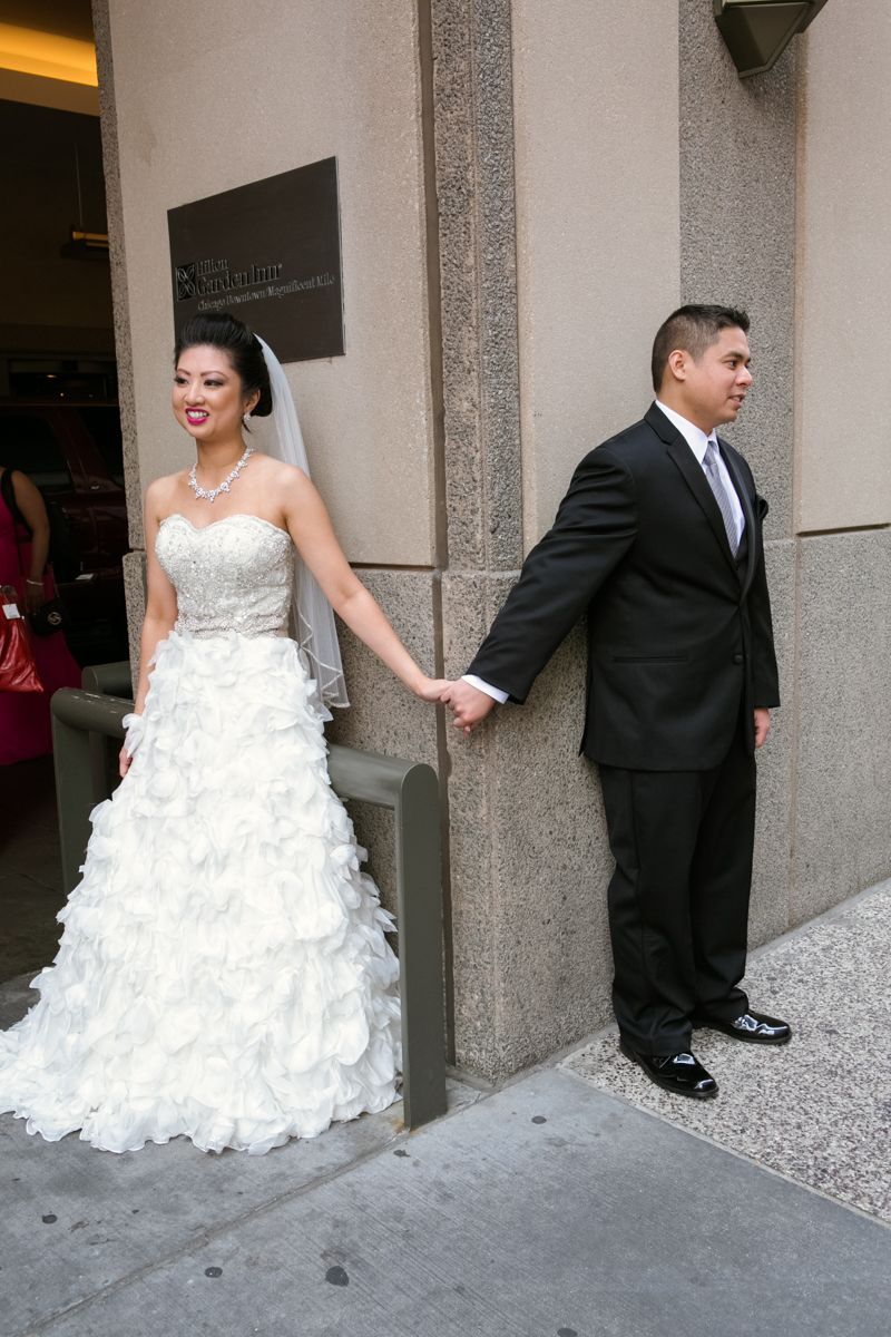 Traditional first look moment between couple around corner of building.