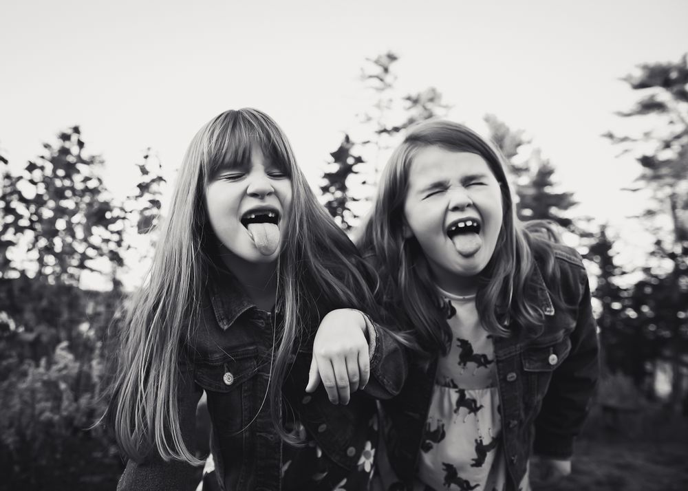 sisters are silly in front of the camera and stick out their tongue