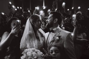 A wedding celebration at night surrounded by guests holding sparklers.