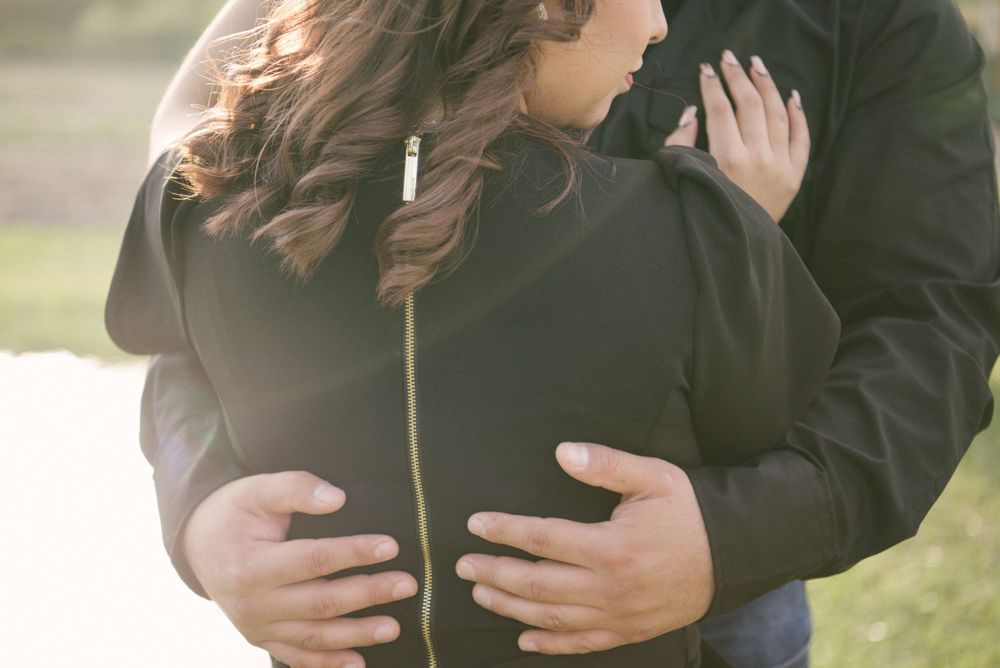 Couple cuddling and hugging in front of the lake. McAllen wedding photography