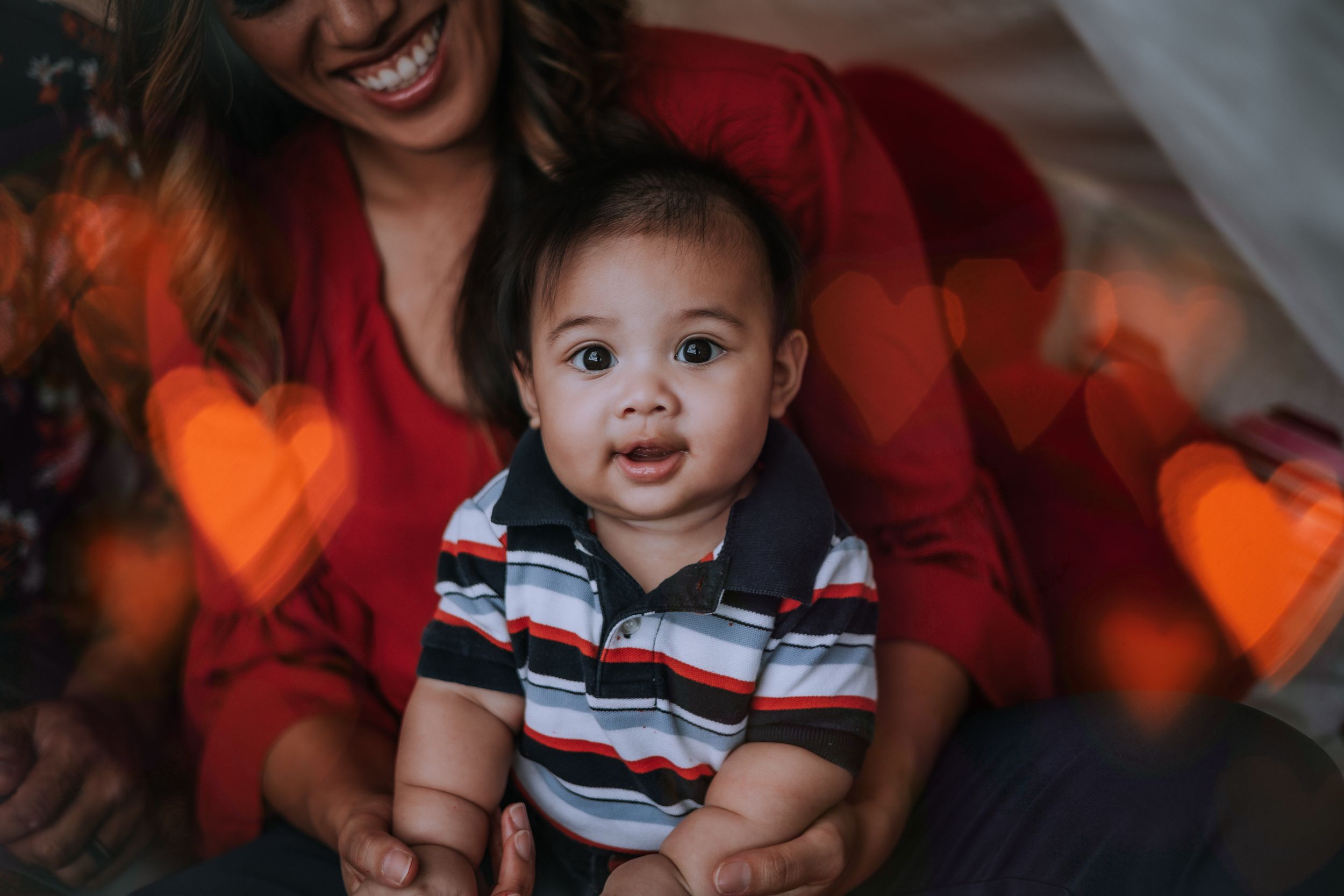 Warm holiday portrait with glowing heart-shaped bokeh effects.