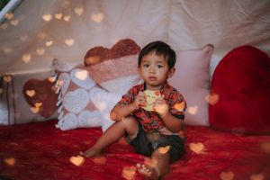 Cozy tent setup with red blankets and heart-shaped lighting effects.
