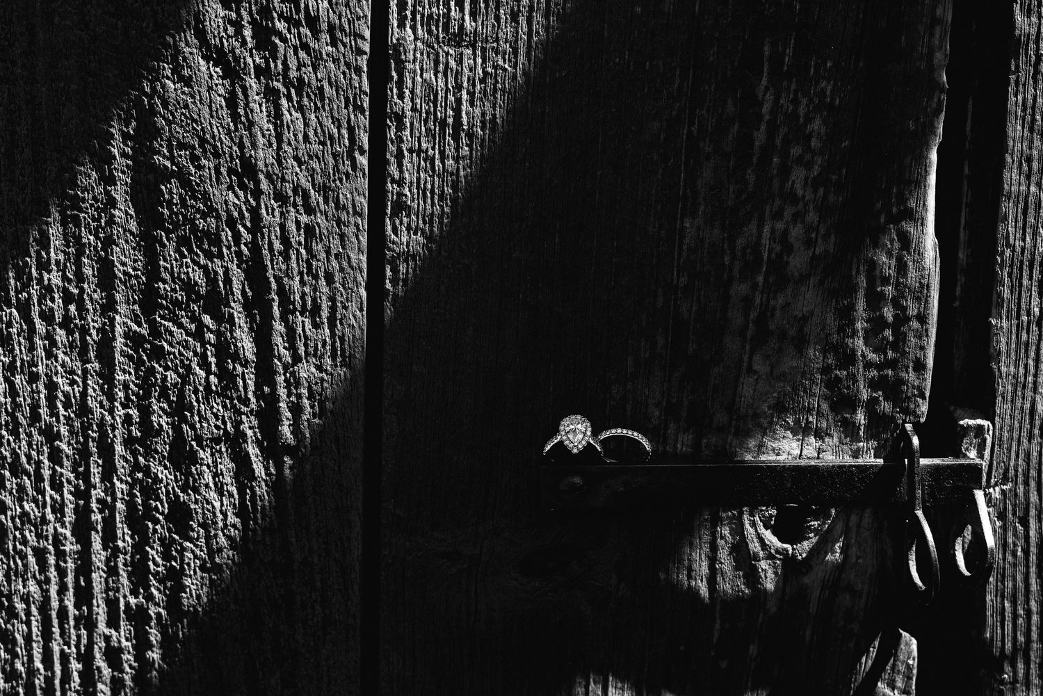 Close-up of an engagement ring resting against a rustic wooden background, emphasizing texture and timeless elegance