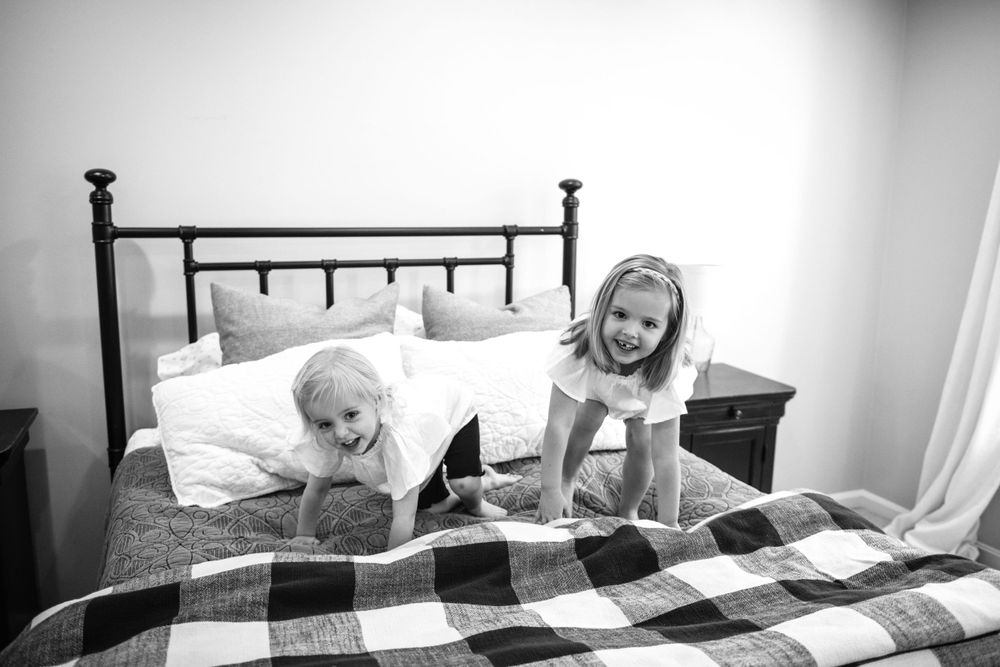 Black and white portraits of family bonding on a plaid bedspread.