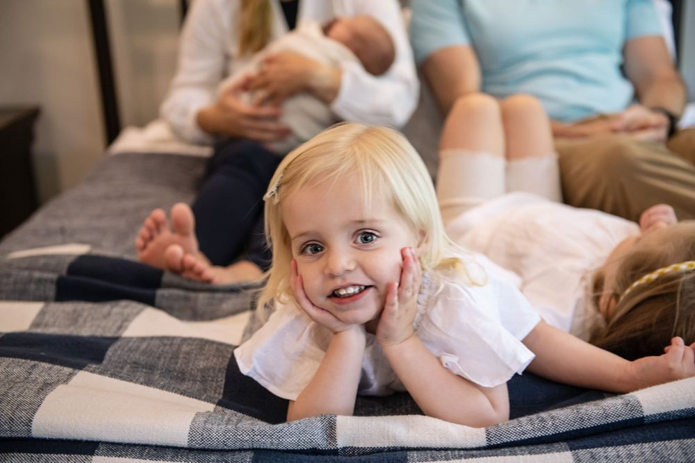Happy moments captured during a casual family photoshoot on bed.