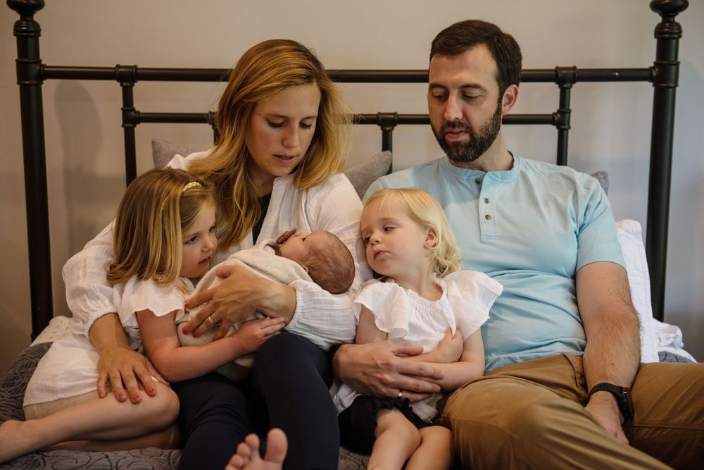 Family lifestyle session showing tender moments on a cozy bed.