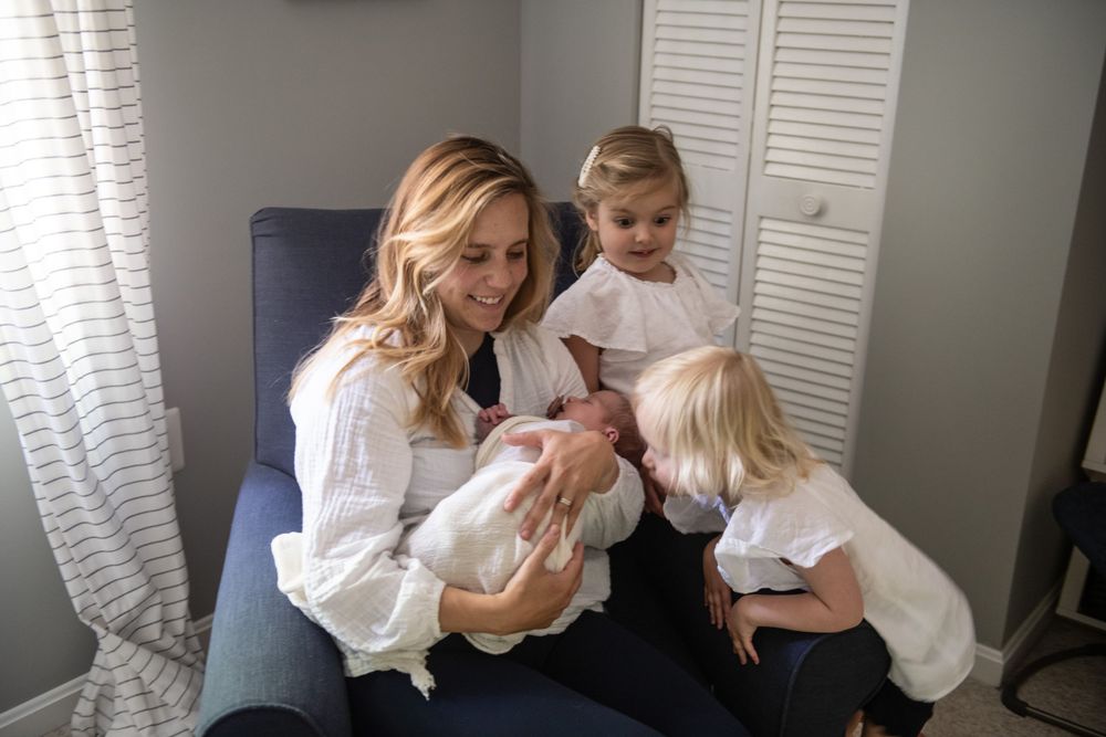 Heartwarming moment as young children gather around to meet their new sibling.