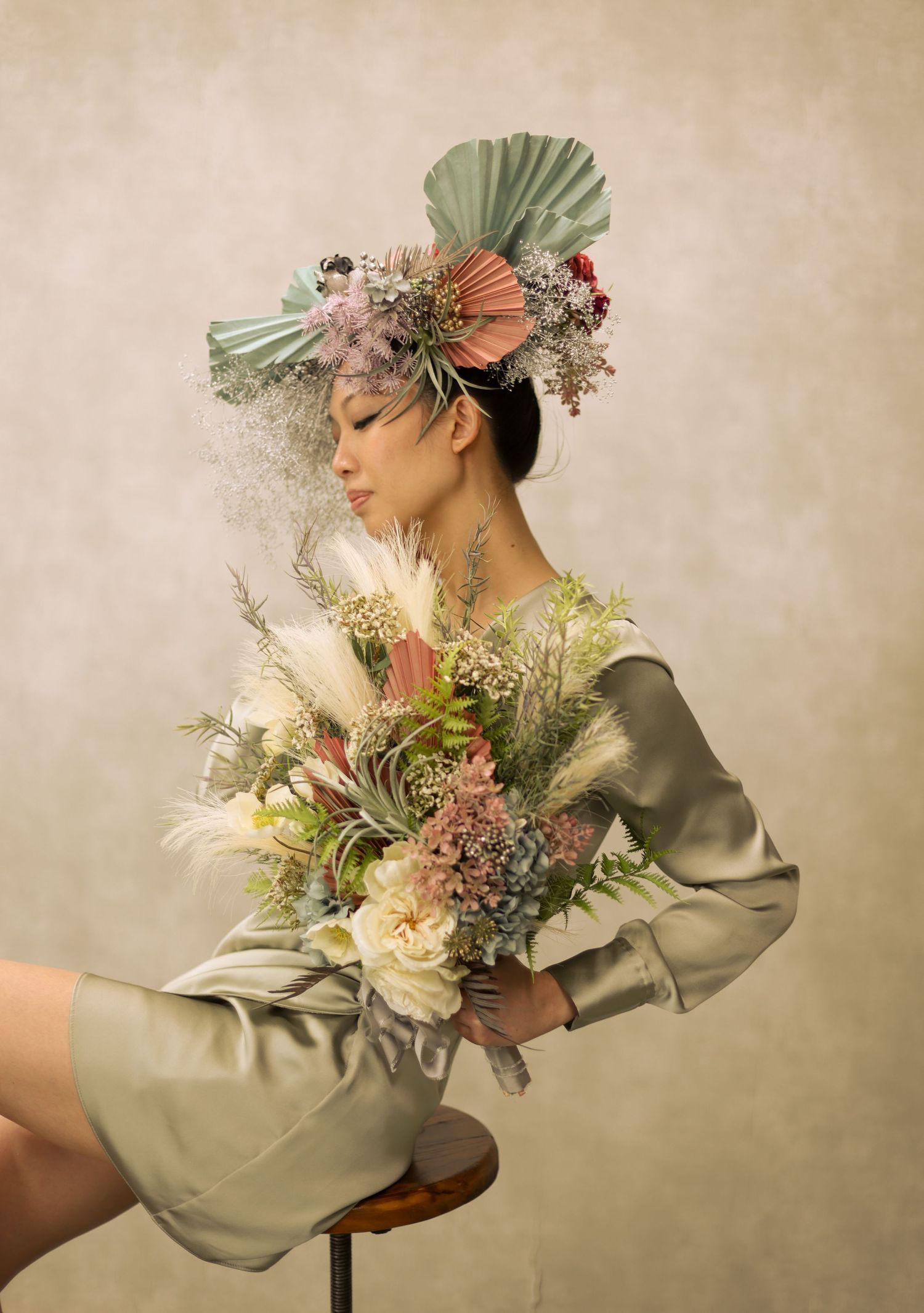 Ethereal fashion portrait with dried flowers and sage green clothing in vintage style.
