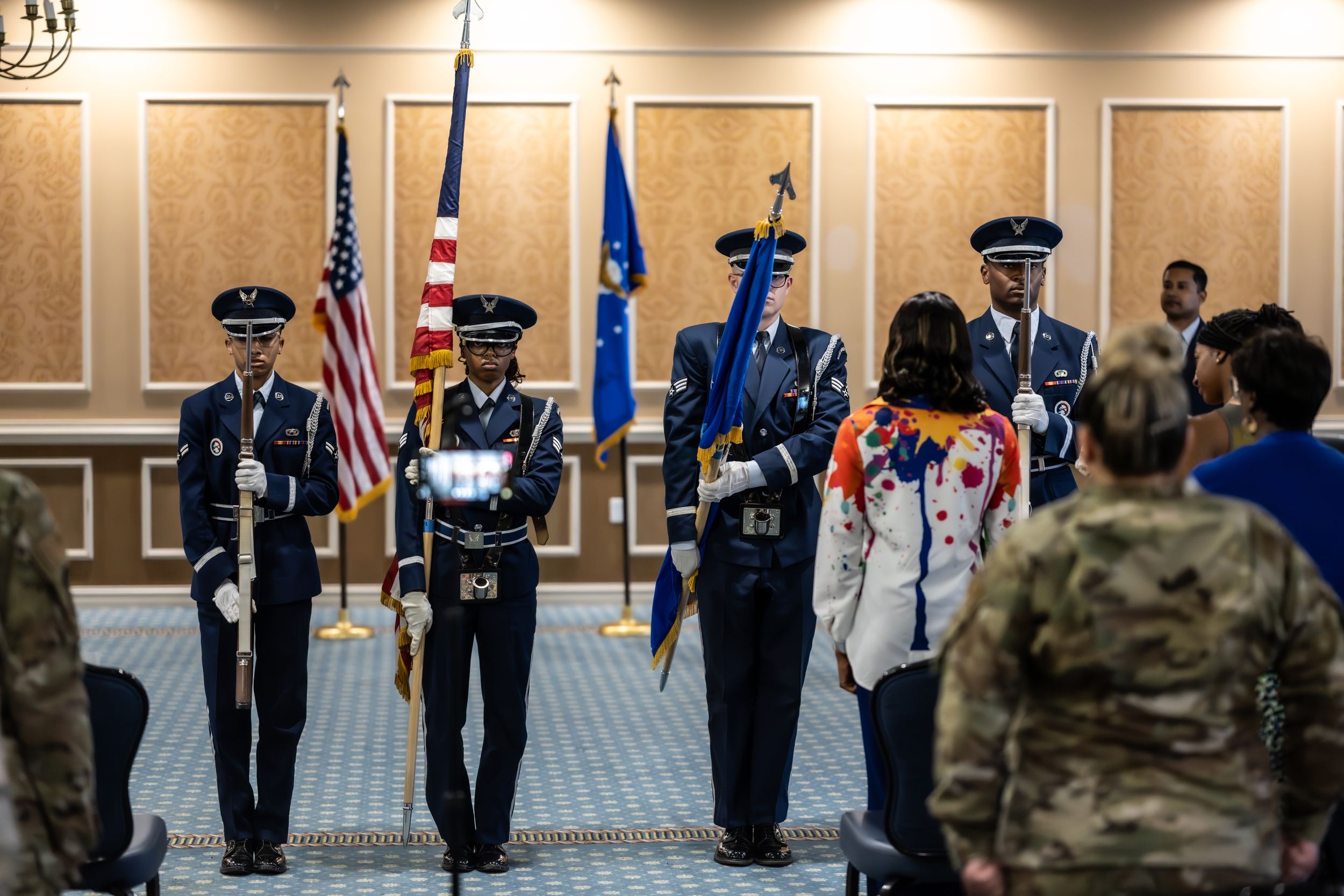 Honor guard performs ceremonial duties with flags during military event.