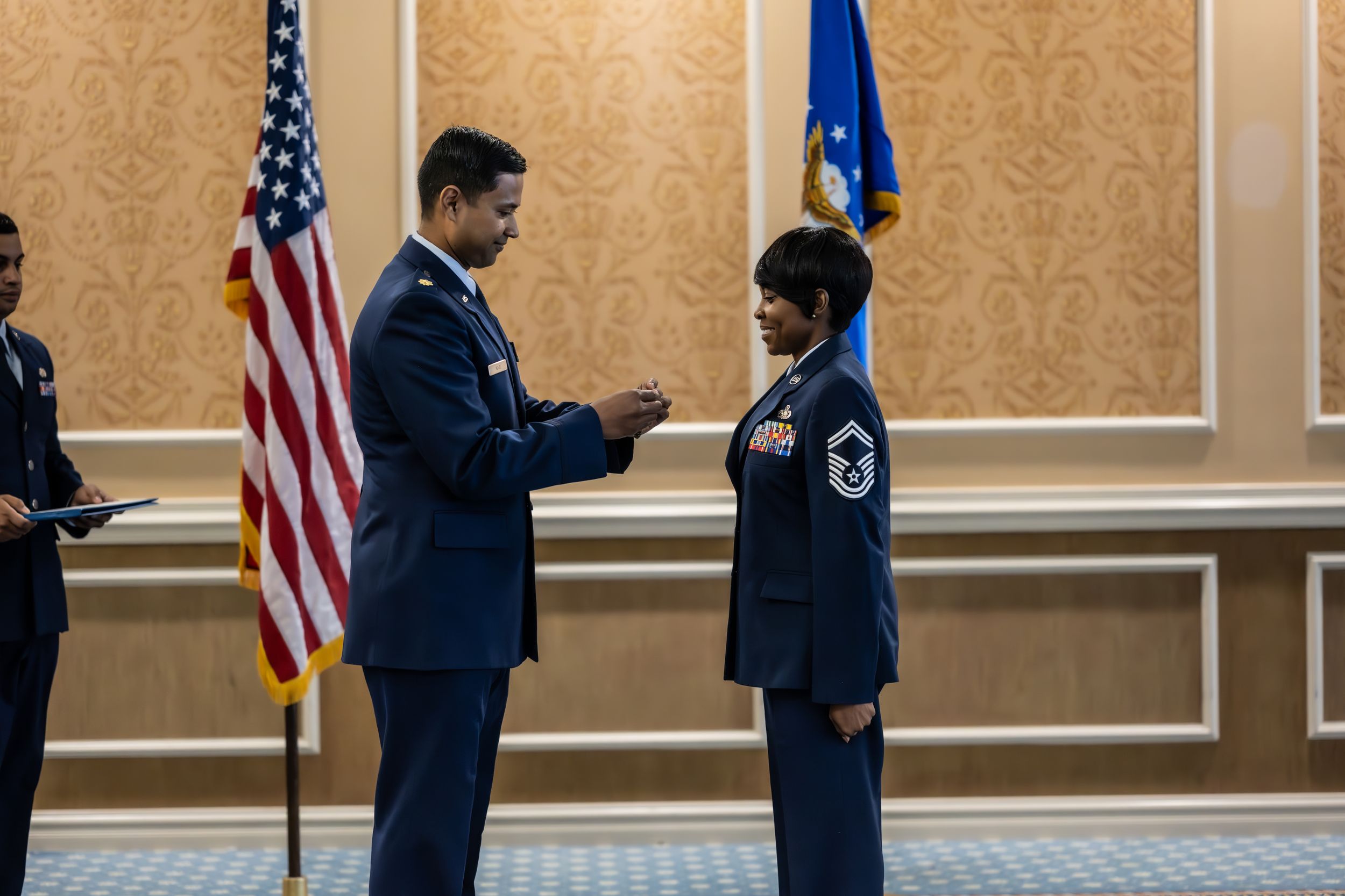 Armed forces members participate in a recognition ceremony in an ornate conference space.