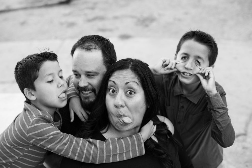 Black and white portrait of family members sharing an intimate moment together outdoors.