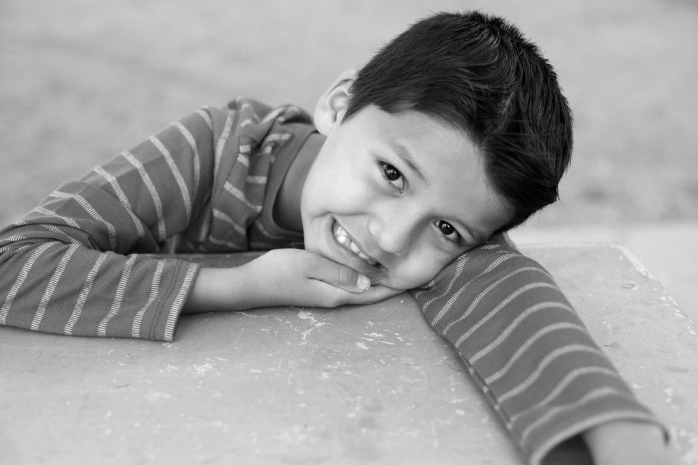Black and white series of a child lying down and posing playfully for the camera.