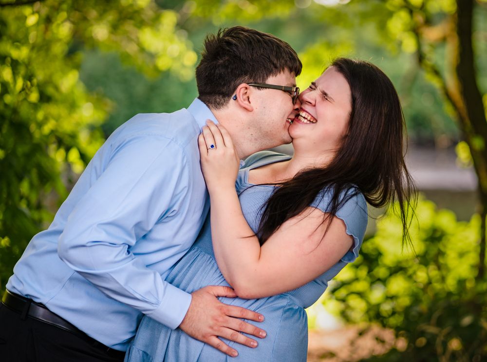 Couple sharing intimate moments in a lush green garden setting during golden hour.