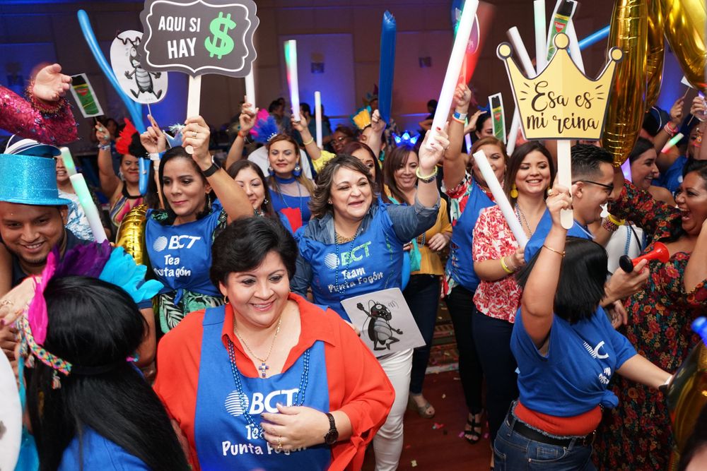 Crowd of enthusiastic supporters celebrating with light sabers and signs at a rally.