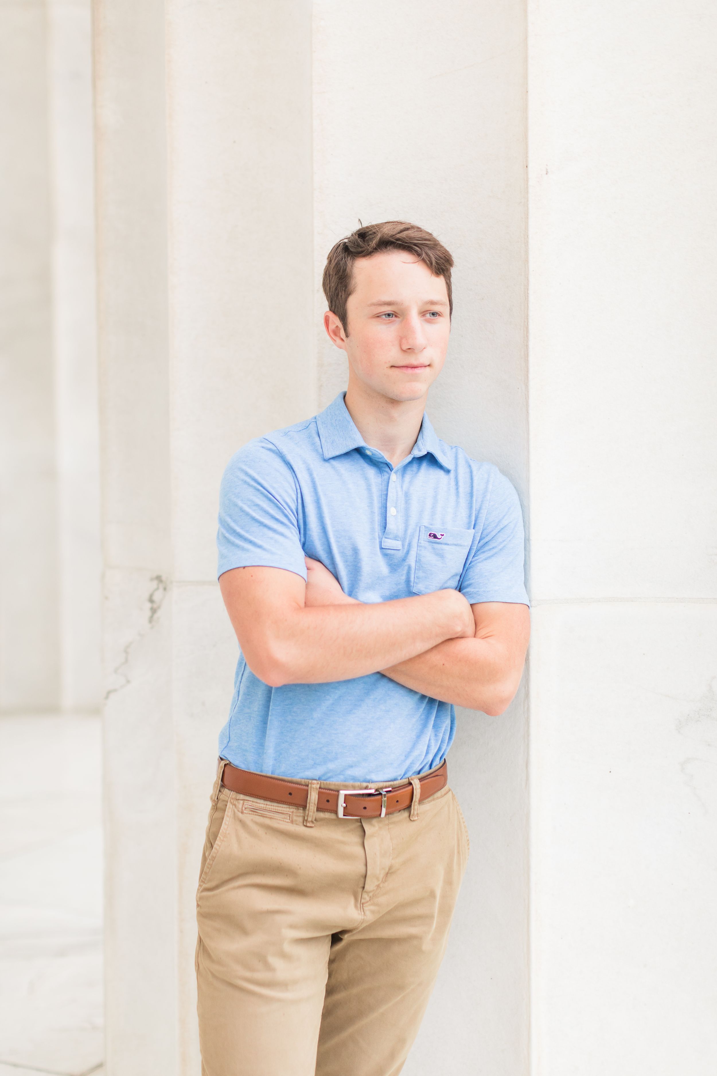 Senior boy leaning against white column