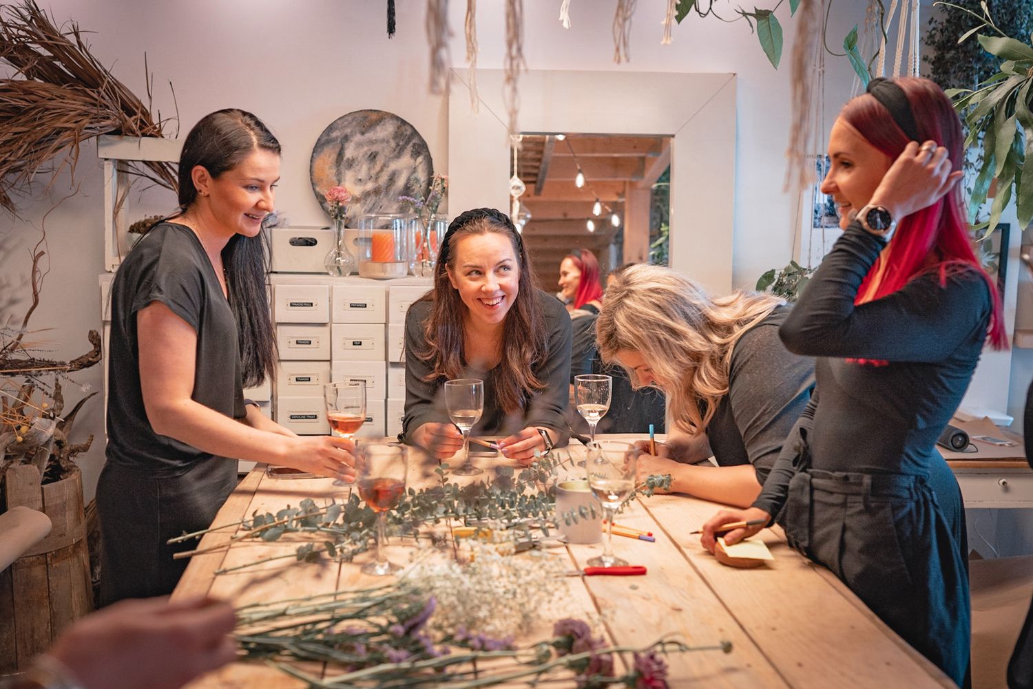 People gathered around a table during a flower arranging workshop.