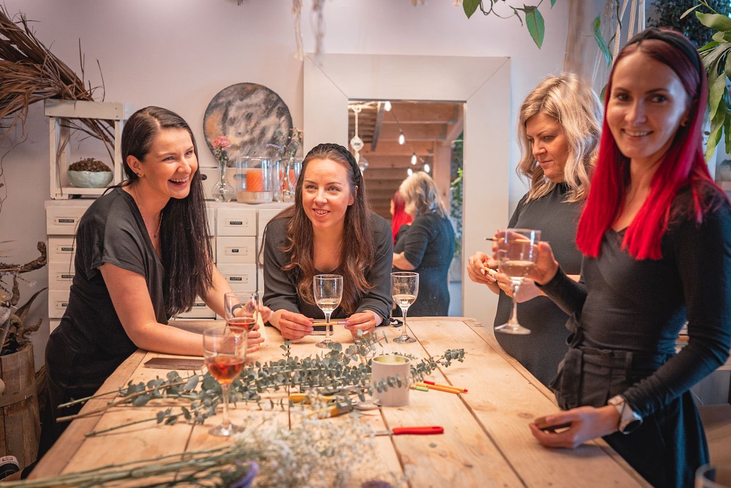 Friends enjoying wine and conversation during a creative workshop session.