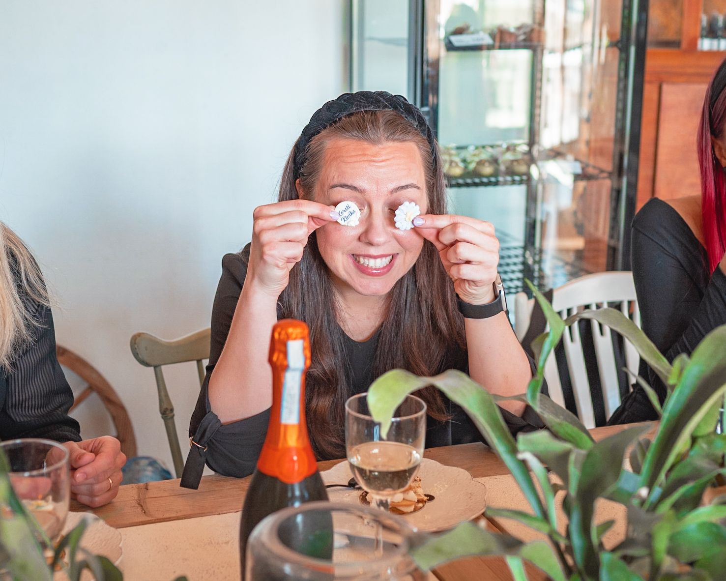 Someone playfully poses with decorative elements at a casual dining table.