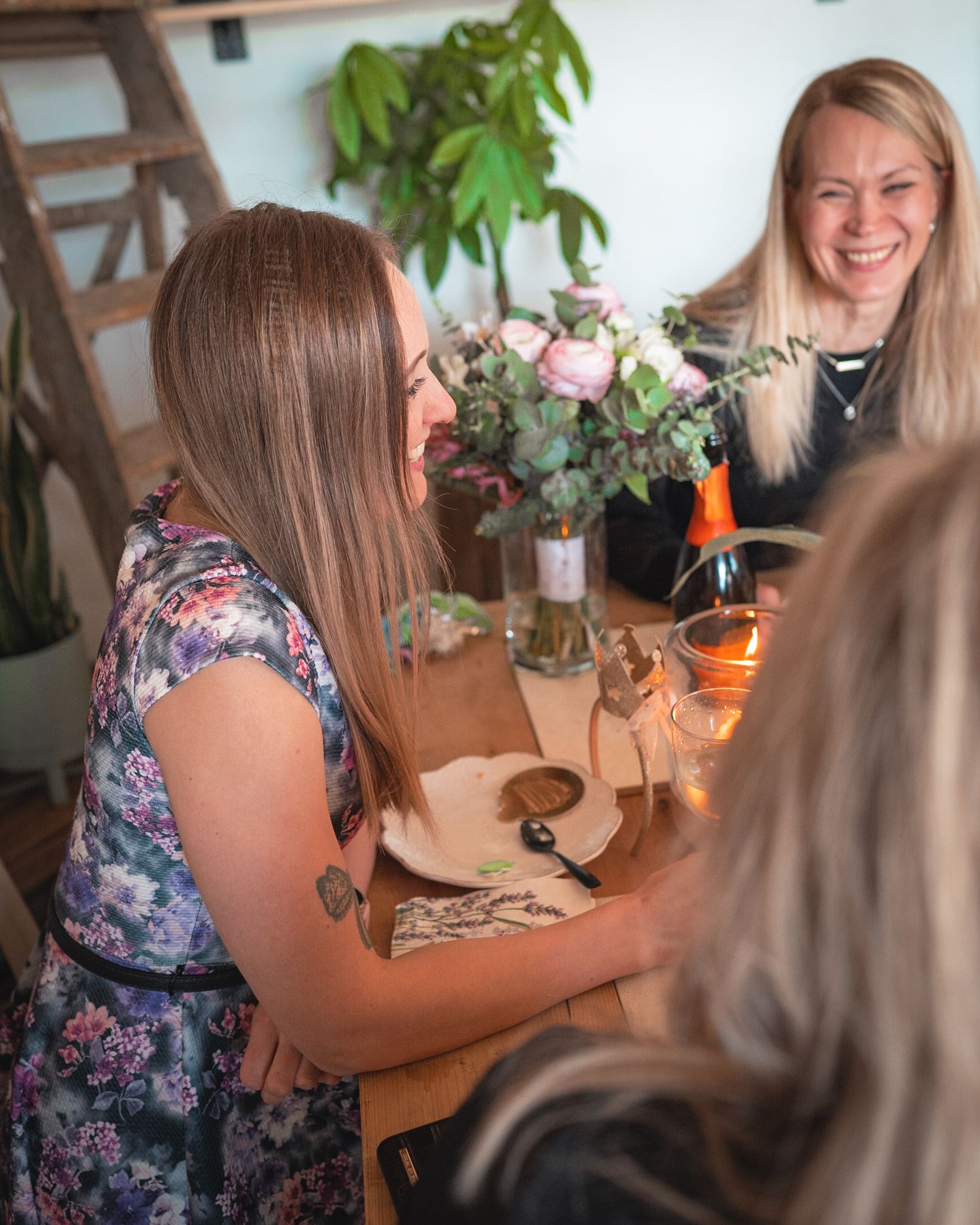 Casual gathering in a plant-filled dining space with floral arrangements.