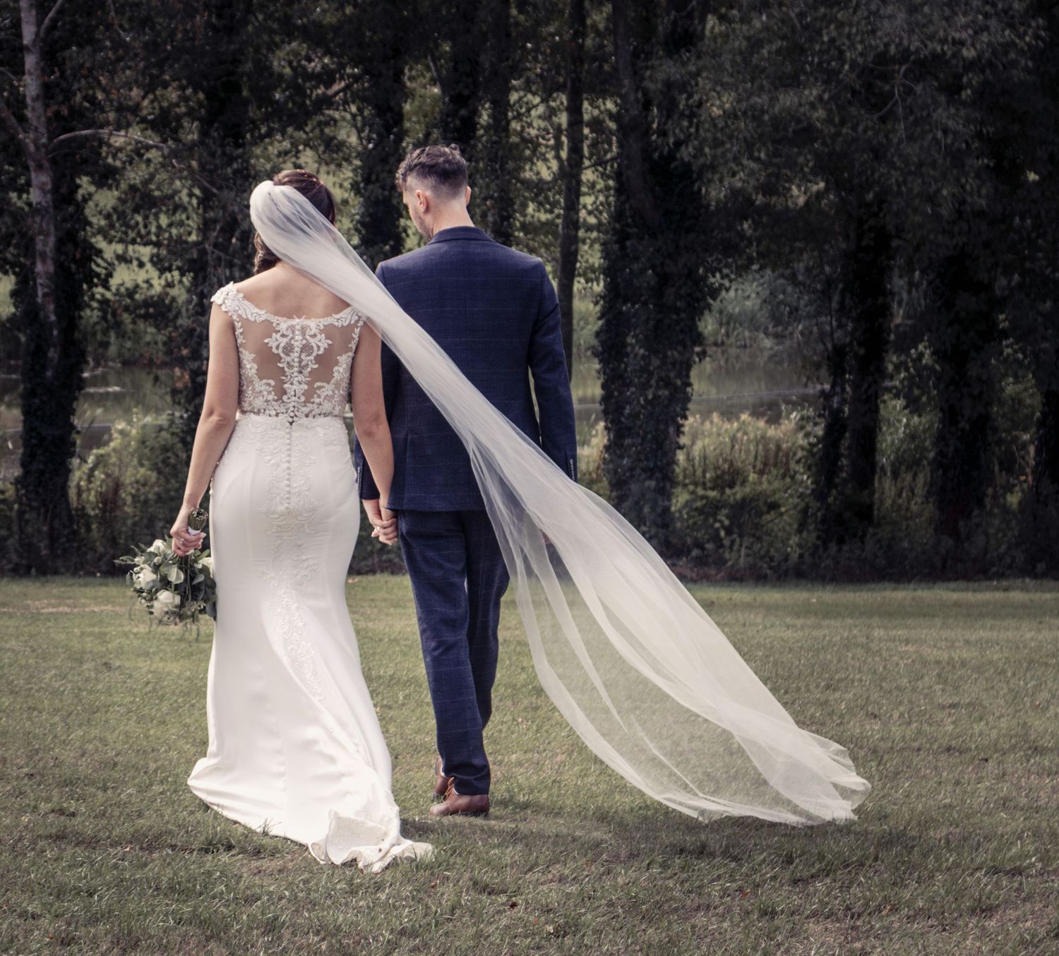 Black and white wedding portraits featuring flowing veil shots in a natural outdoor setting.