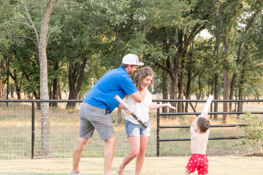 Playful outdoor interaction in a sunny park setting with wooden fence backdrop.