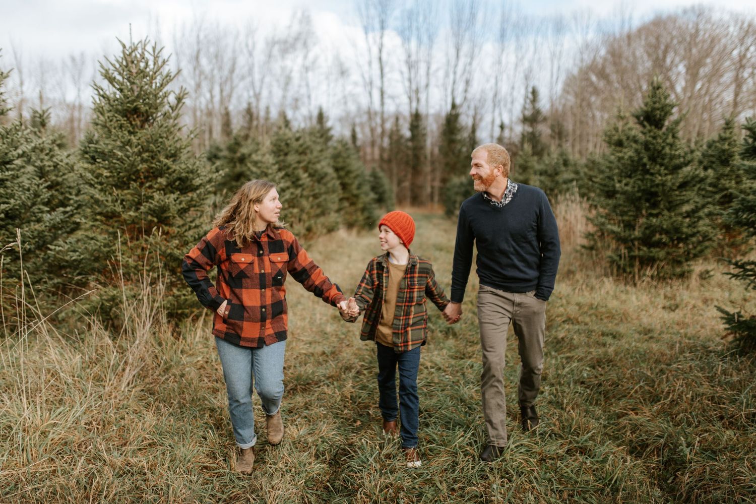 A family in a beautiful field holding hands and laughing
