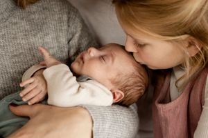 Sister kissing her baby brother newborn sibling photo