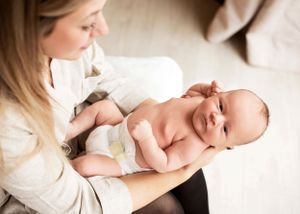 Newborn baby looking at camera from his mum's arms in Bridport Dorset