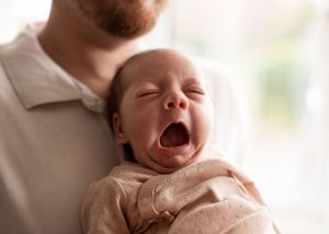Cute newborn baby yawn in light studio style setting