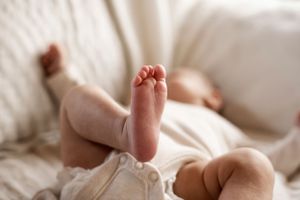 Newborn baby closeup details tiny toes with baby blurred in background