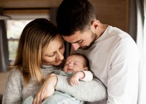 Intimate family of three portrait with newborn baby in centre