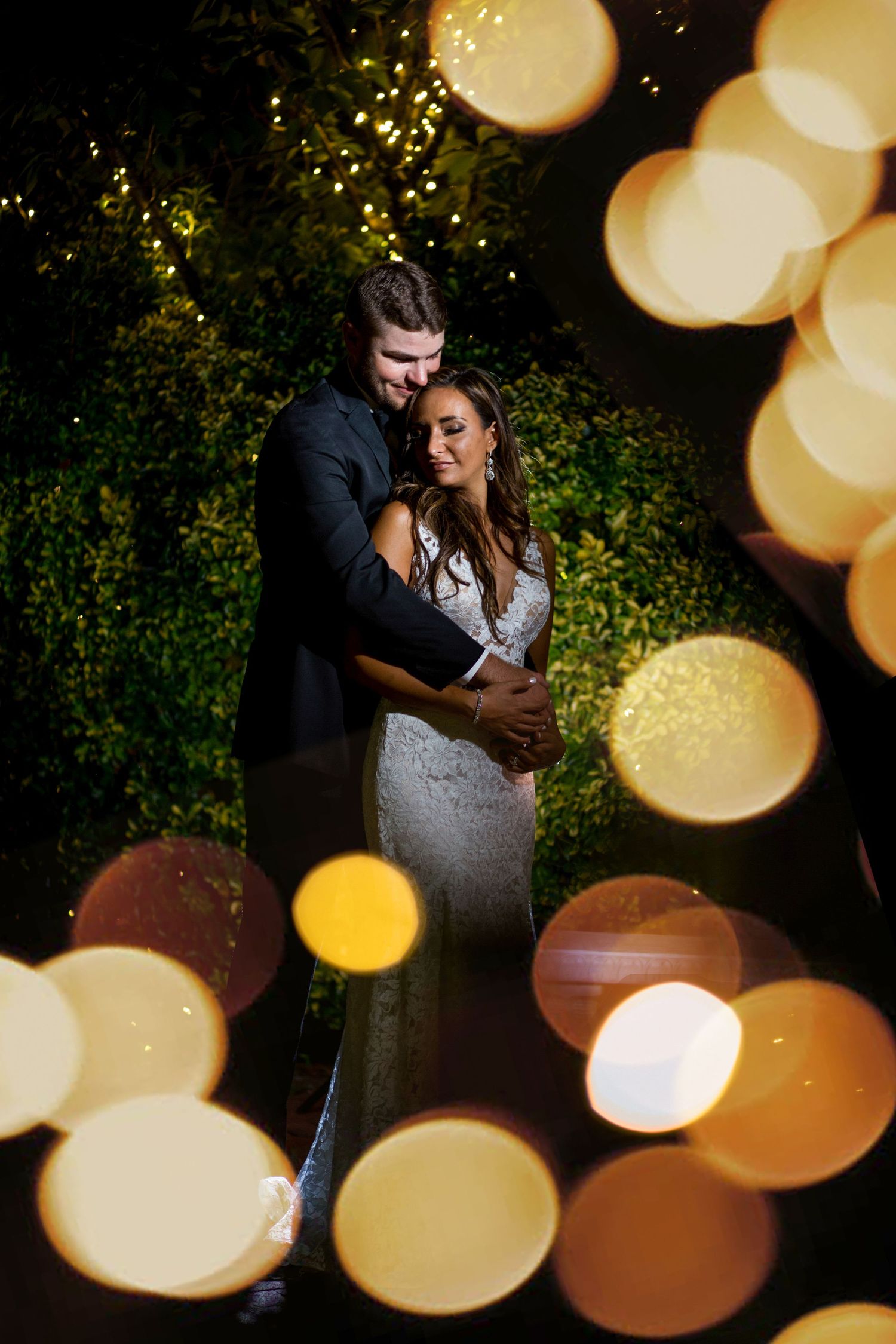 A romantic wedding portrait with dreamy bokeh lights creating a magical atmosphere in the evening.