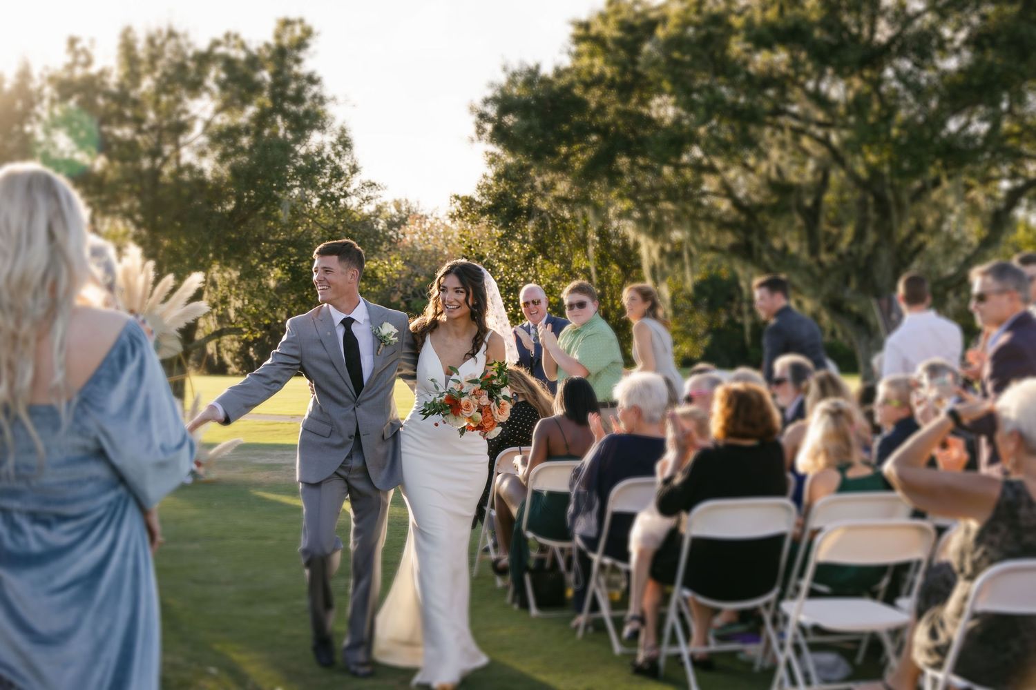 Photo of bride and groom at Lone Palm Golf Club venue. Boho wedding with dried palms. Bradenton wedding photographers