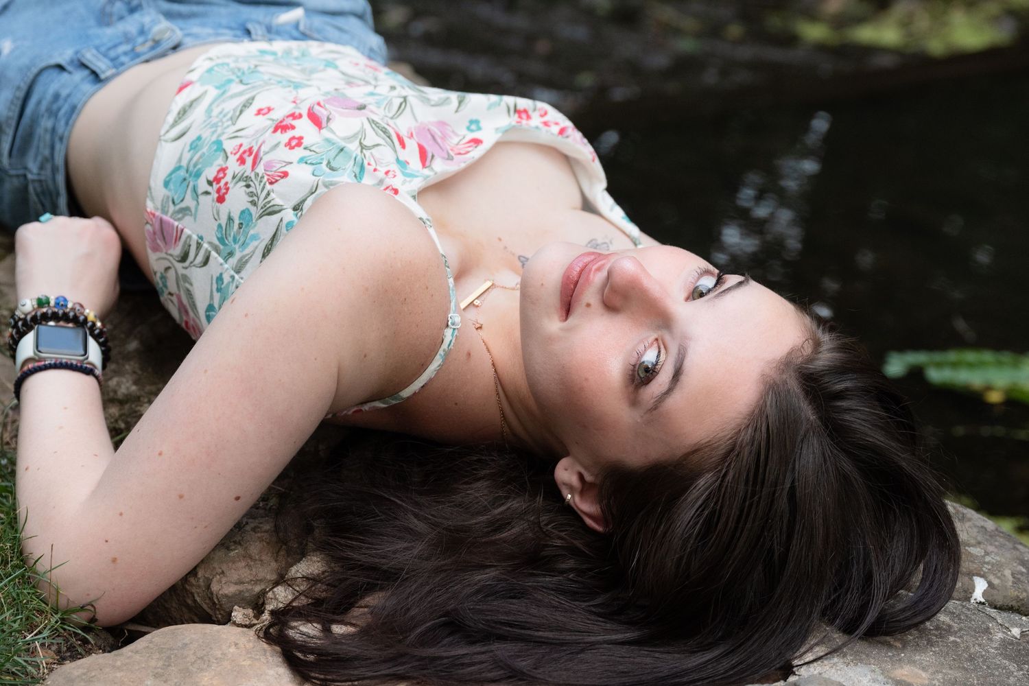 Artistic portrait series with floral patterns against dark water background.