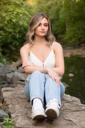 Casual outdoor portraits taken on large rocks with natural scenery in the background.
