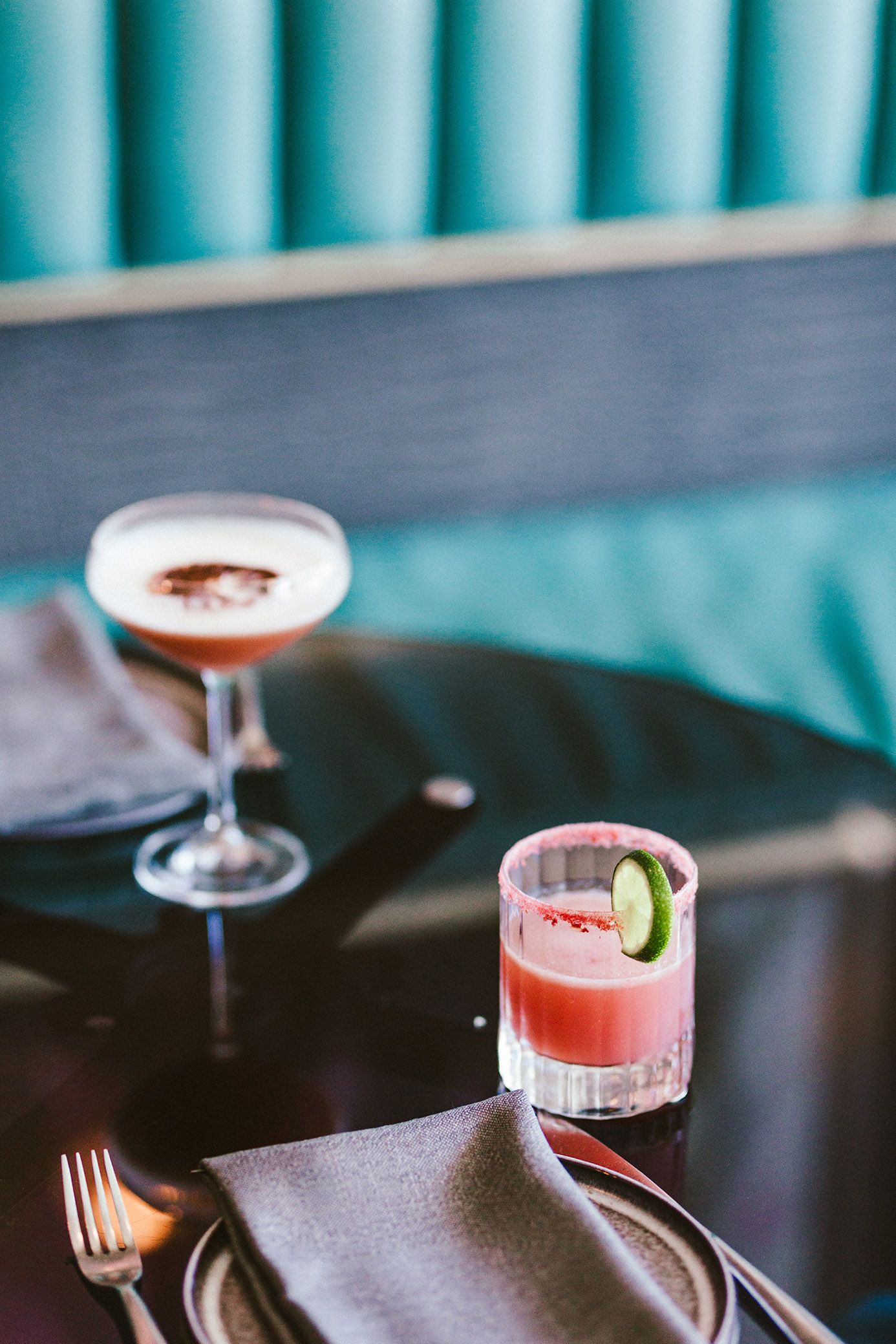 Pink cocktails and table settings against a turquoise backdrop.