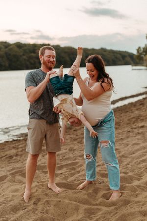 A joyful family moment at sunset on a sandy beach.